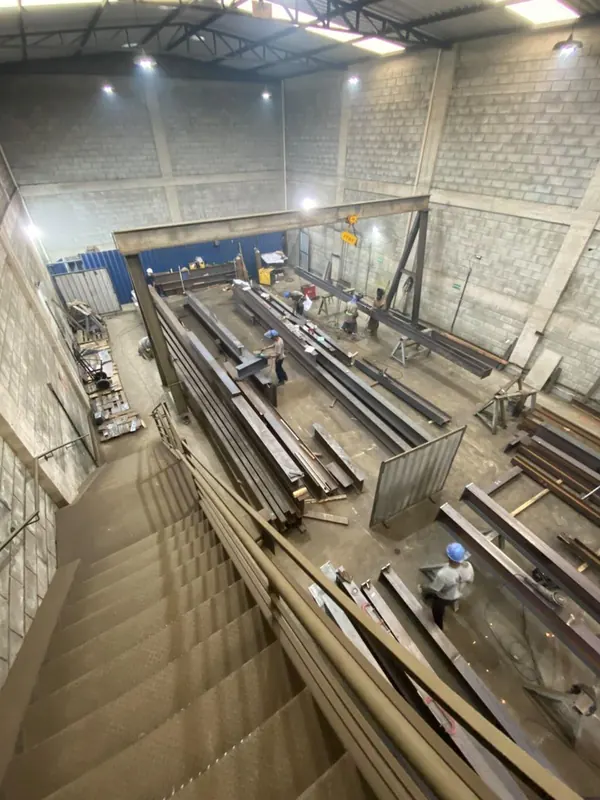 Equipe fabricando os perfis do elevador de carga, vista do alto da fábrica