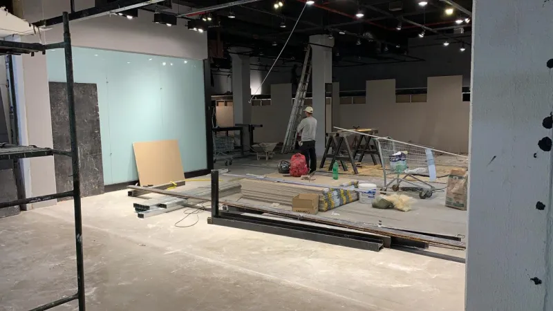 Estrutura do mezanino em montagem no salão, com andaimes ao fundo