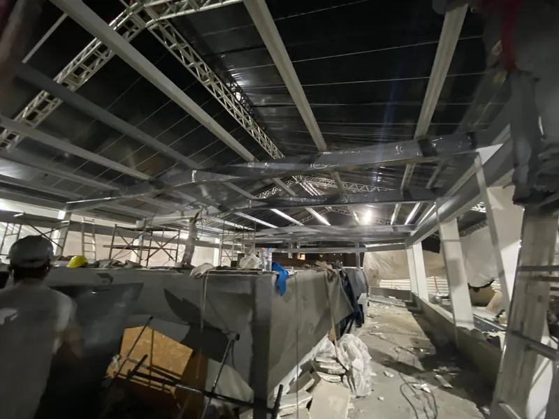 Vigas da nova estrutura vistas de baixo, com montador em primeiro plano