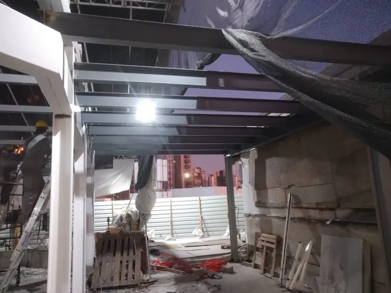 Vigas da marquise montadas à noite, com montador no andaime
