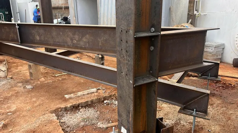 Pilar e vigas metálicas aparafusados sobre a placa de base, na obra