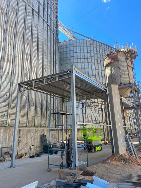 Estrutura da cobertura sobre a passarela técnica, com andaime e plataforma elevatória